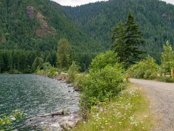 A gravel road on a causeway next to a lake.