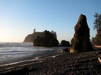A beach with large stone sea stacks.
