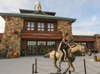 A metal sculpture of two people riding a horse is located at the entrance plaza for the Archway Building, a large stone, wood, and metal structure