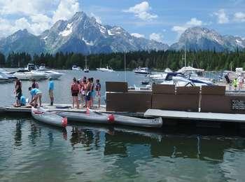 Visitors preparing to go canoeing on Jackson Lake from the Colter Bay Marina. Standing on dock with life jackets on.