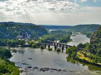 view of Harpers Ferry from Loudoun Heights in May; railroad bridges, the town, the rivers, and canal towpath are all visible in photo