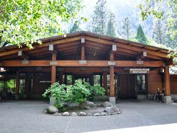 A building made of wooden beams, posts, and planks has a sign reading,