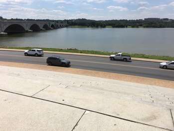 Steps lead down to a road and the Potomac River. The Arlington Memorial Bridge can be seen on the left. 