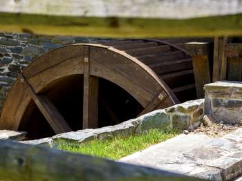 A wooden circular mill surrounded by a stone canal
