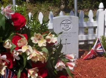 Wreaths and flags from the United Kingdom, Canada, and the United States of America decorate the gravesite.