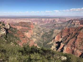 An open canyon vista of steep slopes, sheer cliffs, deep valleys and a multitude of layered rock