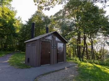 Small brown structure with slanted roof and two doors.