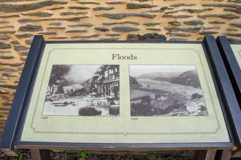 Close-up of wayside in front of stone wall.