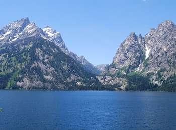 A view across Jenny Lake looking toward Inspiration Point at the mouth of Cascade Canyon with the Cathedral Group peaks to the left and Mt. St. John to the right.