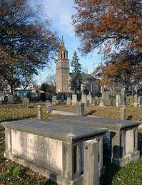 The steeple of St. Paul’s Church is framed by fall leaves and the gravestones and tombs of its centuries old cemetery.