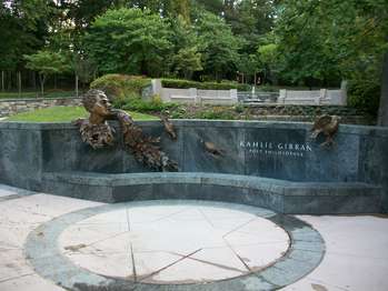 A stone bench memorial with a bronze bust of Kahlil Gibran