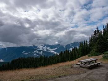 A picnic table with a view of distant mountains.