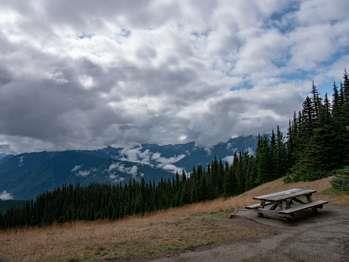 A picnic table with a view of distant mountains.