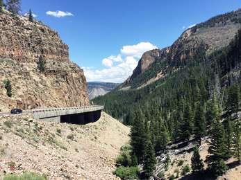 A modern concrete bridge snugly fits against a steep canyon