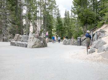 Visitors walk along the wide, paved path leading to the Artist Point Overlook.