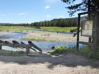 Flagg Canyon boat launch with log ramp to slide rafts down to the Snake River. Visitors fishing on the gravel bar.