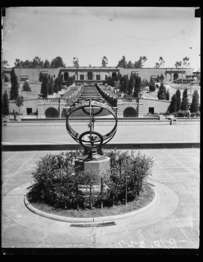 Historic photo of a metal armillary sphere at the base of a cascading waterfall.