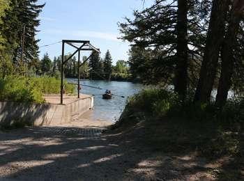 Drift boat preparing to land at Moose with a boat lift above.