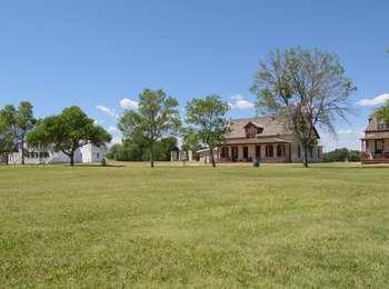 Restored historic, wood building surround the grass parade grounds of Fort Laramie