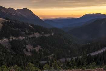 A road winds up a mountain at sunrise.