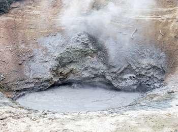 Mud bubbles up from a hole surrounded by rock