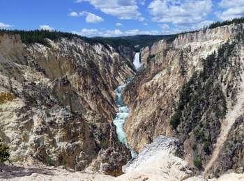 Sweeping view of a yellow canyon marked by a wide waterfall at the end