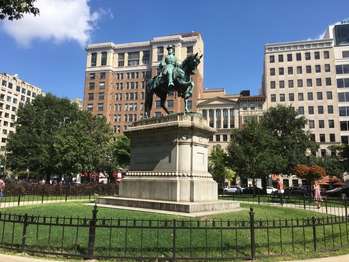 A statue of Major General James B. McPherson on a horse on top of a pedestal in a circular patch of grass.
