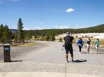 People photographing and walking on sidewalk