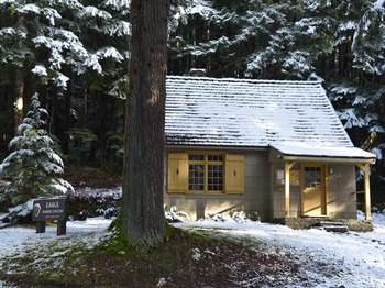 A small house in the snow. The sign out front reads 