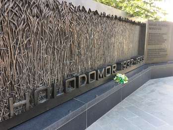 A boquet of flowers sit on a bench of the Holodomor Memorial 