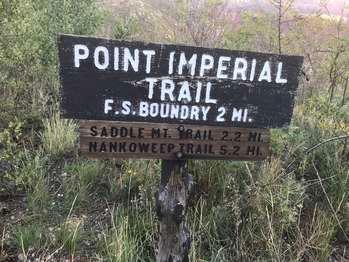 A old weathered wooden sign with white lettering reads