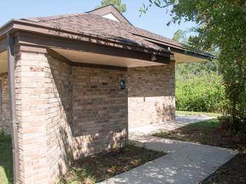 Brown brick building with a small, white, women's restroom symbol.