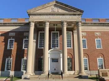 Close-up of the red brick and white trim Historic Truman Courthouse, with its entrance columns