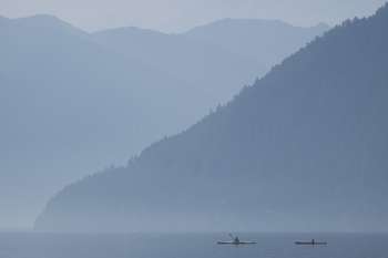 Two kayaks on a serene lake.