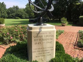 A large sundial on top of a pedestal reading