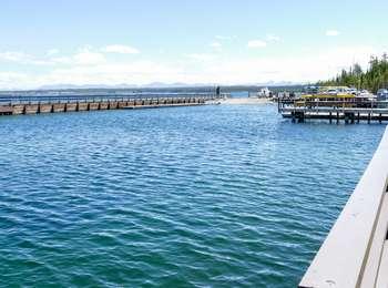 Boat ramp is straight ahead with docks to left and right with pier also on left and water in marina