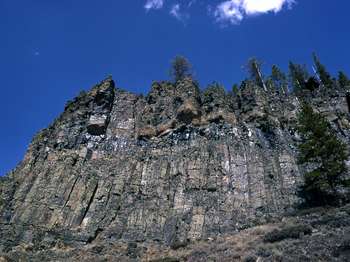 Columns of hexagonal rock form a cliff that rises high into the air.
