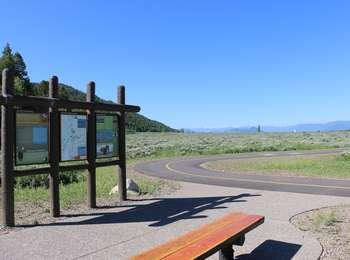 Ditch Creek Pathway access and trailhead sign with bench in foreground.
