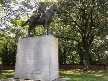 A statue of Bernardo de Galvez riding a horse on top of a granite pedestal