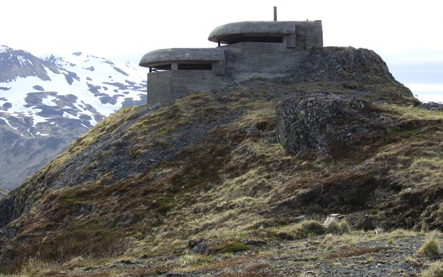 a grey building sits on a hill a grey building sits on a hill