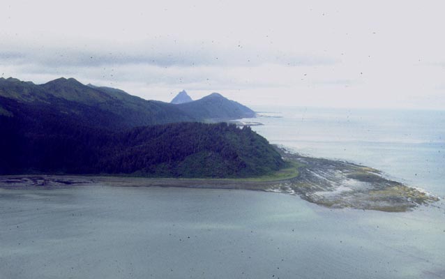 An island beach with a sloping mountain in background An island beach with a sloping mountain in background