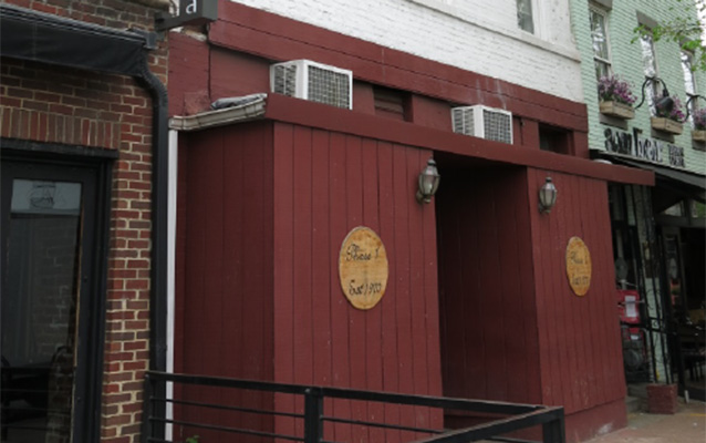 Exterior of Phase One with wooden siding and medallion-shaped signage