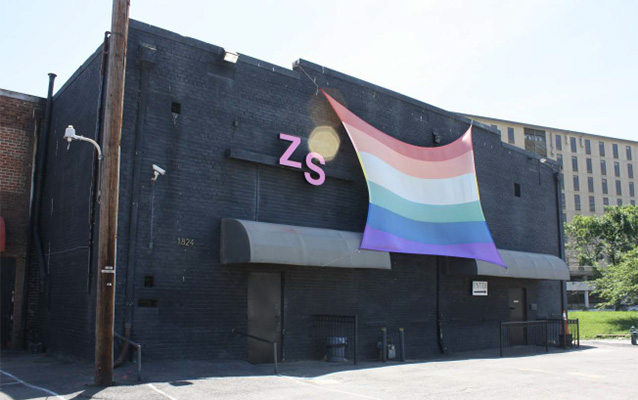 Black commercial building with a large pride flag
