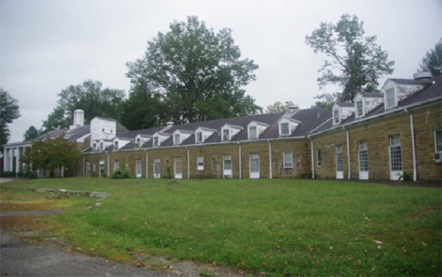 Exterior view of several long, single-story buildings.