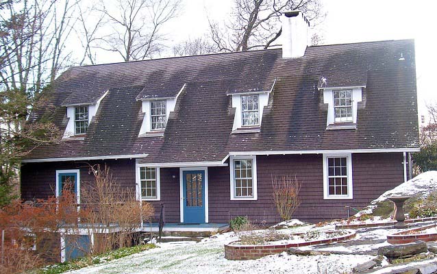 Exterior view of a brown wood-sided, two-story house.