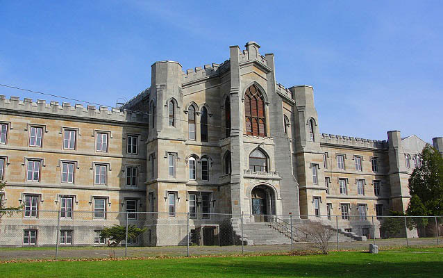 Exterior of a brick institutional building with gothic-style towers.