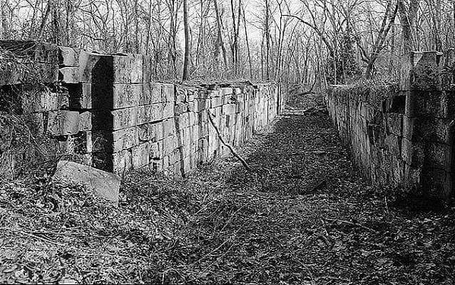 A two derelict walls on either side of an empty canal A two derelict walls on either side of an empty canal