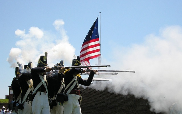 Soldiers fire their weapons in Fort McHenry reenactment