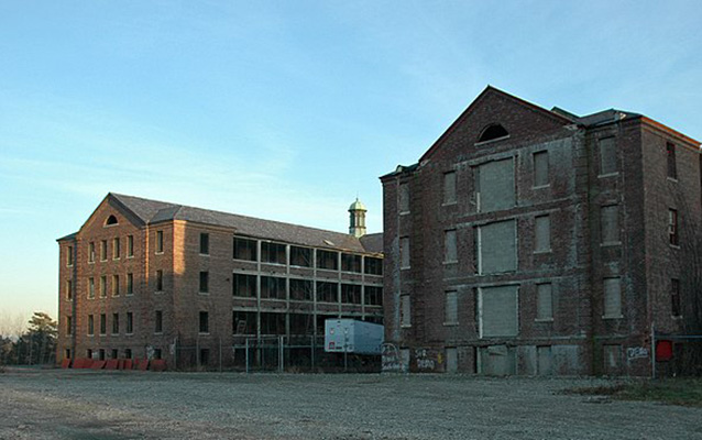 Exterior of a brick building with boarded up windows.