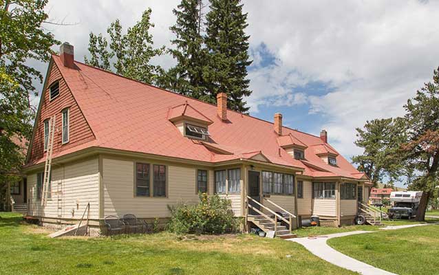 Tan wooden building with red tin roof.